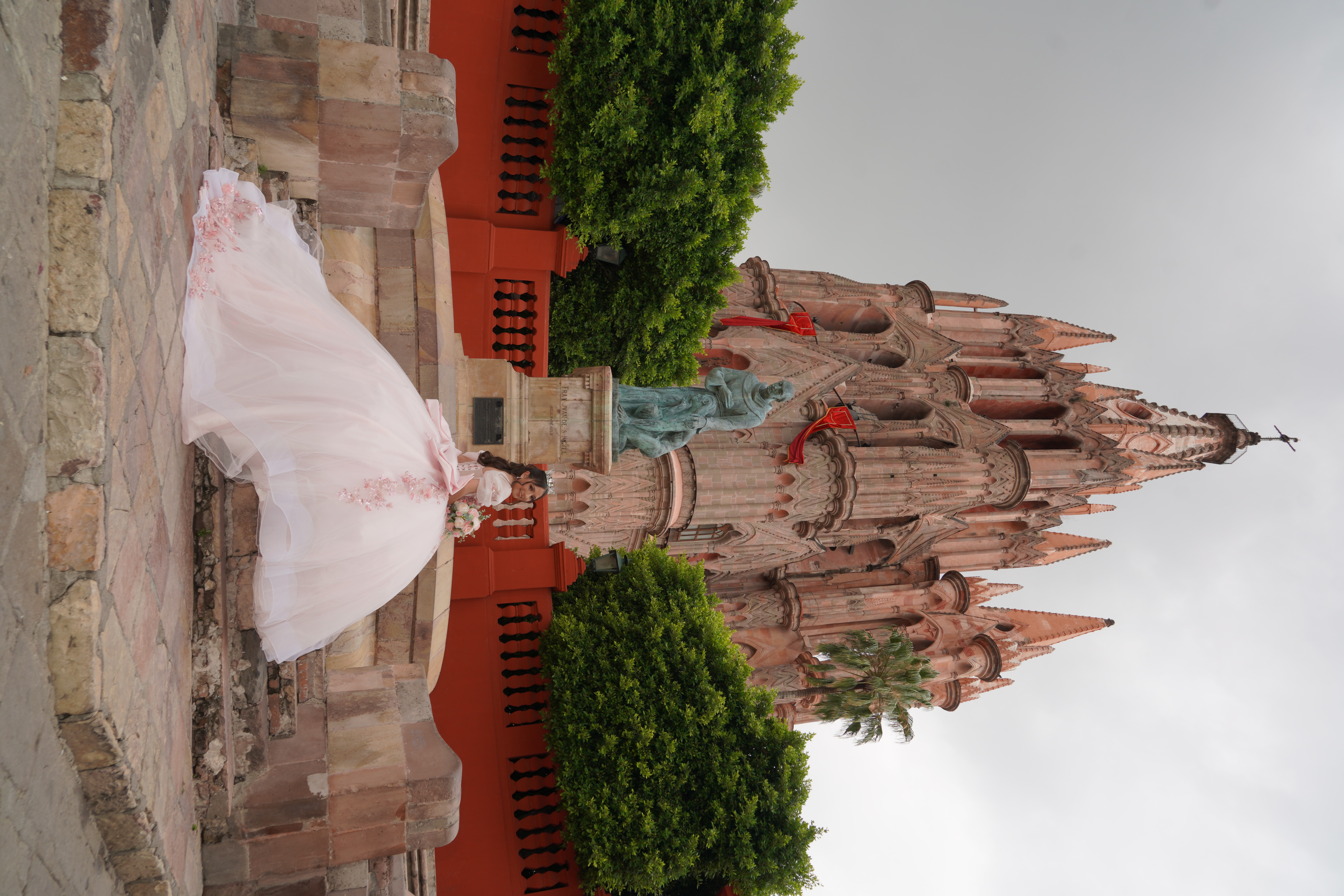 Valeria frente a la parroquia con vestido rosa